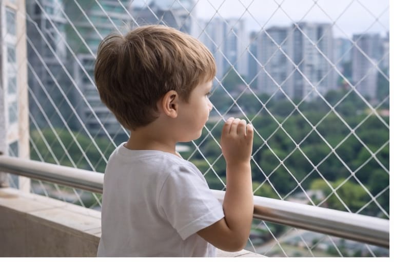 Bebé seguro en balcón con malla de protección